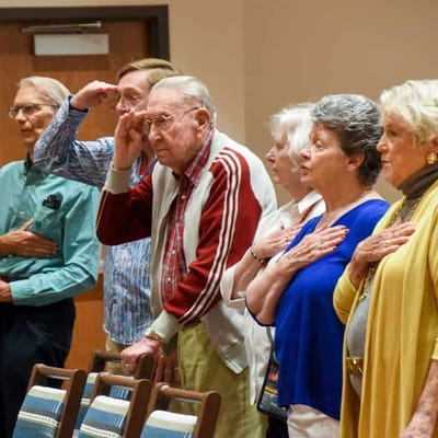 Residents participating in a patriotic ceremony indoors