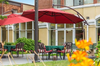 Outdoor seating area with red umbrellas and flowers