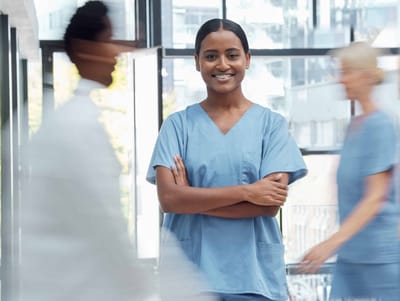 A nurse smiling in a blurred corridor