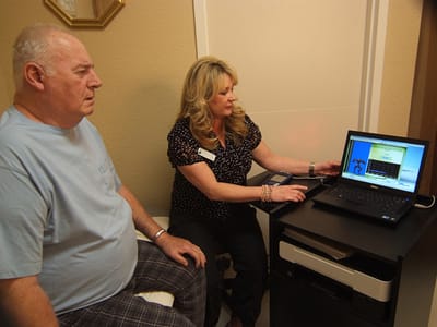 A resident and staff member interacting at a computer