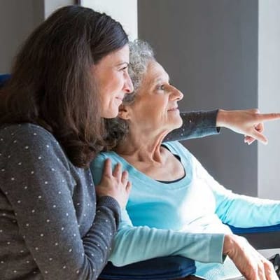 A resident and staff member interacting in a bright common area