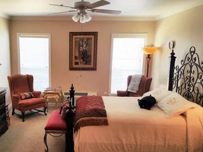 A cozy resident bedroom with seating and decor