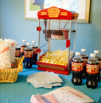 Popcorn machine with soft drinks and snacks on a table