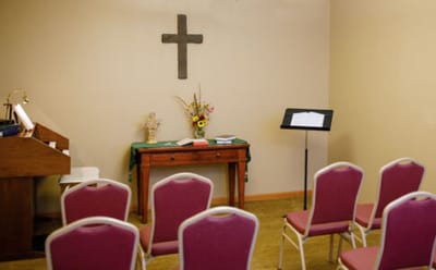 Interior view of a chapel with chairs and a cross