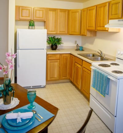 Bright kitchen area with wooden cabinets and dining table
