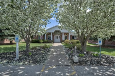 Front entrance of Eden Vista surrounded by trees in bloom