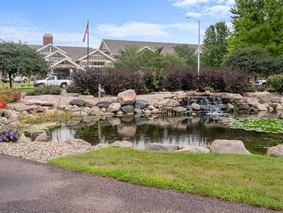 Beautiful landscaping with a pond and the facility in the background