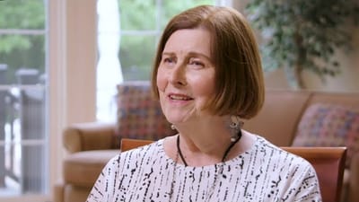 A smiling resident engaging in conversation indoors