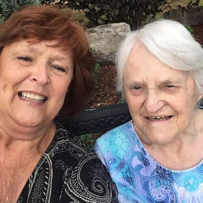 Two residents smiling together outdoors
