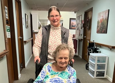 Staff member assisting a resident in a hallway