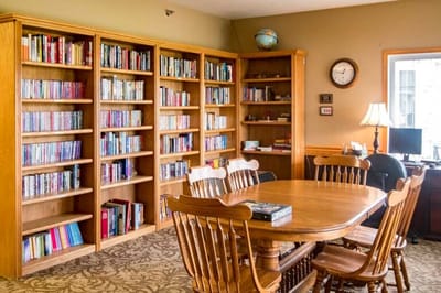 Cozy library area with bookshelves and a dining table