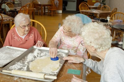 Residents baking together in a bright activity room