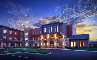 Exterior view of a senior living facility at sunset