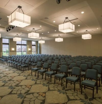 A well-lit activity room with seating arranged in rows