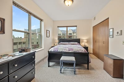 Cozy interior view of a resident room with a bed and dresser