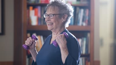 Senior woman exercising with dumbbells in an activity room