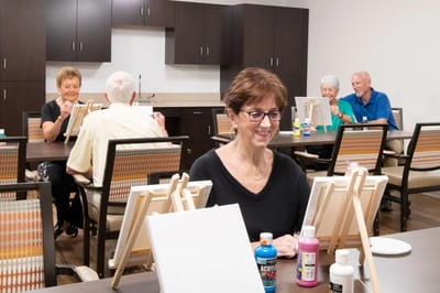 Residents enjoying a painting activity in a spacious room