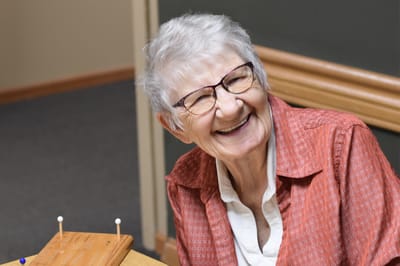 A smiling resident enjoying a game indoors