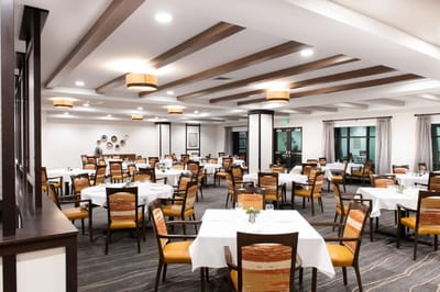 Bright and spacious dining room with tables set for meals