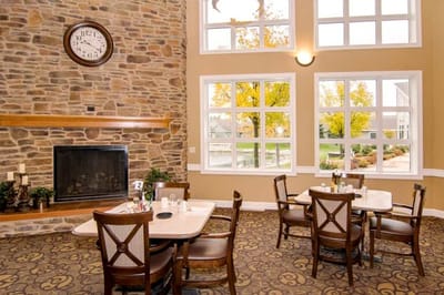 Dining area with stone fireplace and views of garden