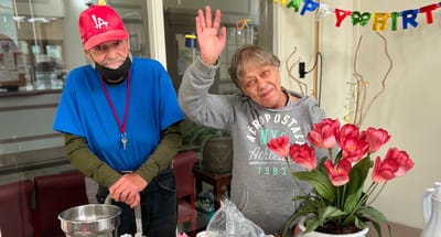 Residents celebrating a birthday with flowers and smiles