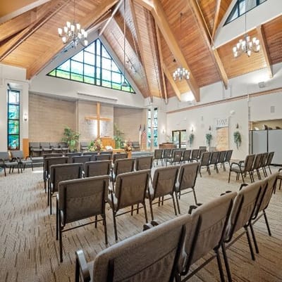 A spacious multi-purpose room with seating and a cross
