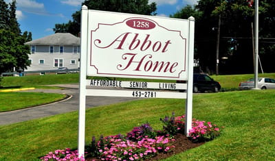 Sign for Abbot Home with colorful flowers