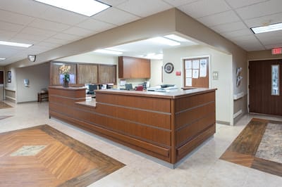 Reception area of a nursing home with a wooden front desk