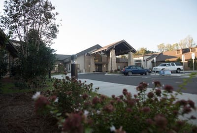 Exterior view of senior living facility with landscaped entrance