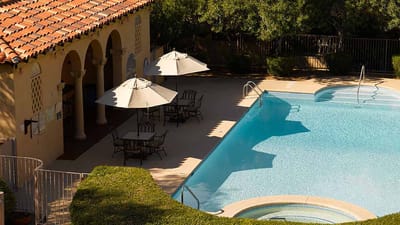 Outdoor swimming pool area with seating and umbrellas