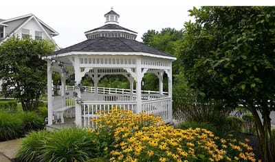 Gazebo surrounded by vibrant flowers in a garden
