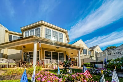 Exterior view of a senior living facility with outdoor seating and gardens