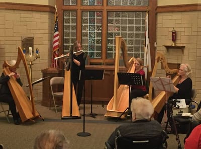 Residents enjoying a harp concert in a common area
