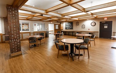 Common area with tables and chairs in a well-lit room
