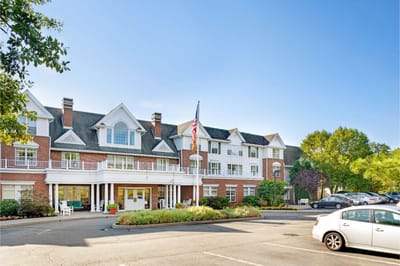 Exterior view of a senior living facility with flag