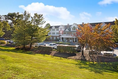 Exterior view of a senior living facility surrounded by greenery