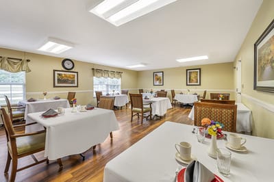 Bright dining room with neatly set tables and decor