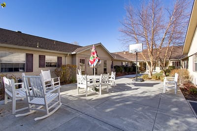Outdoor seating area with rocking chairs and basketball hoop