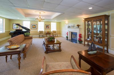 Bright common area with seating and a grand piano