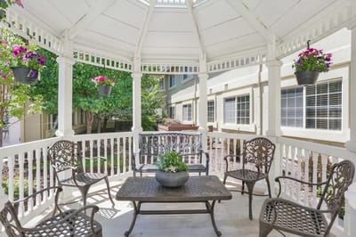 Outdoor gazebo with seating and hanging flowers
