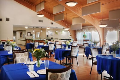 Bright dining room with blue tablecloths and flowers