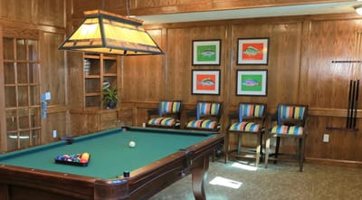 Interior view of a billiards room with colorful chairs