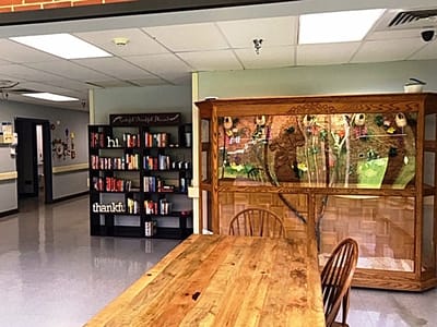 Interior common area with bookshelves and a wooden table