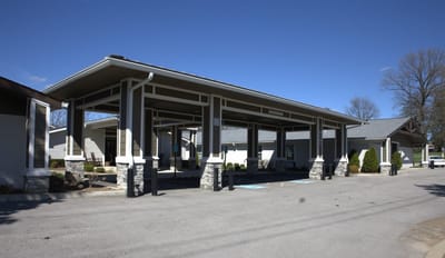 Building exterior with covered entrance and parking area