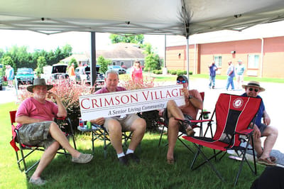 Residents holding a sign for Crimson Village outside