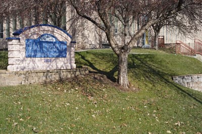 Facility logo sign outside with landscaping