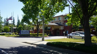 Exterior view of a senior living facility surrounded by greenery