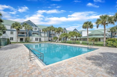 Outdoor pool area with palm trees and building facade