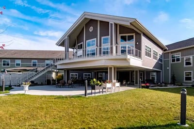 Exterior view of a senior living facility with outdoor seating