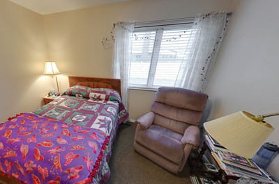 Cozy resident room with bed and armchair